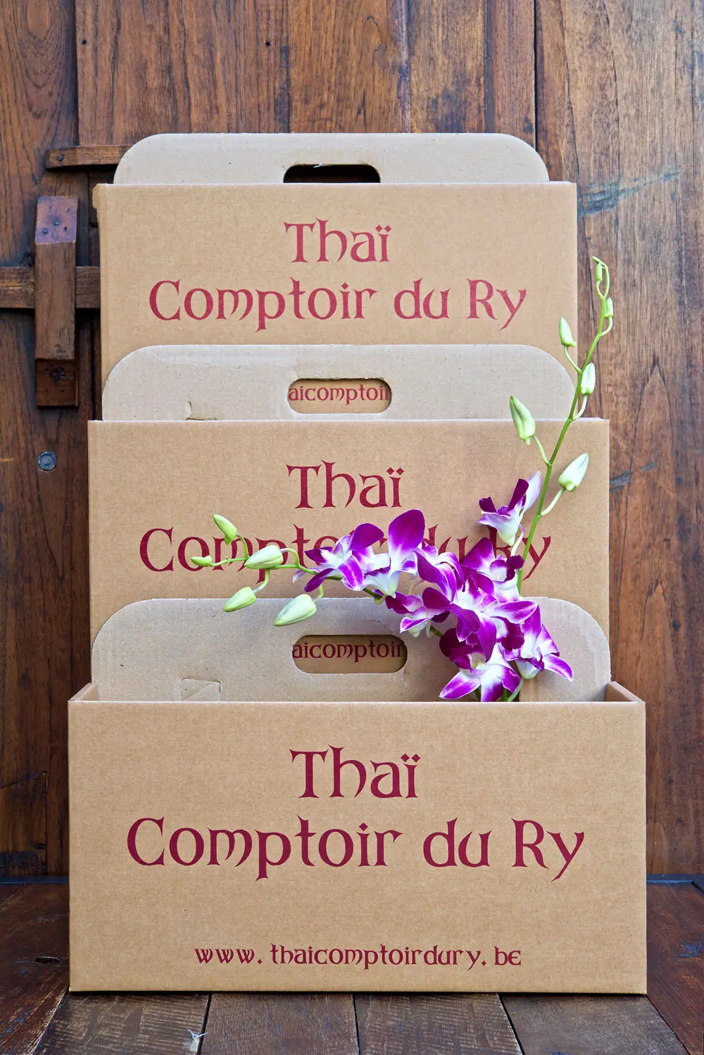 Afhaaldozen van Thaï Comptoir du Ry versierd met orchideeën
