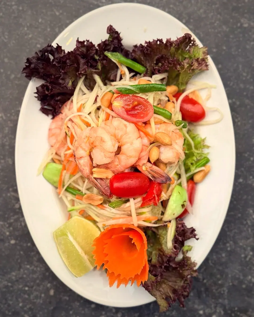Salade van groene papaja met garnalen, kerstomaatjes en pinda’s