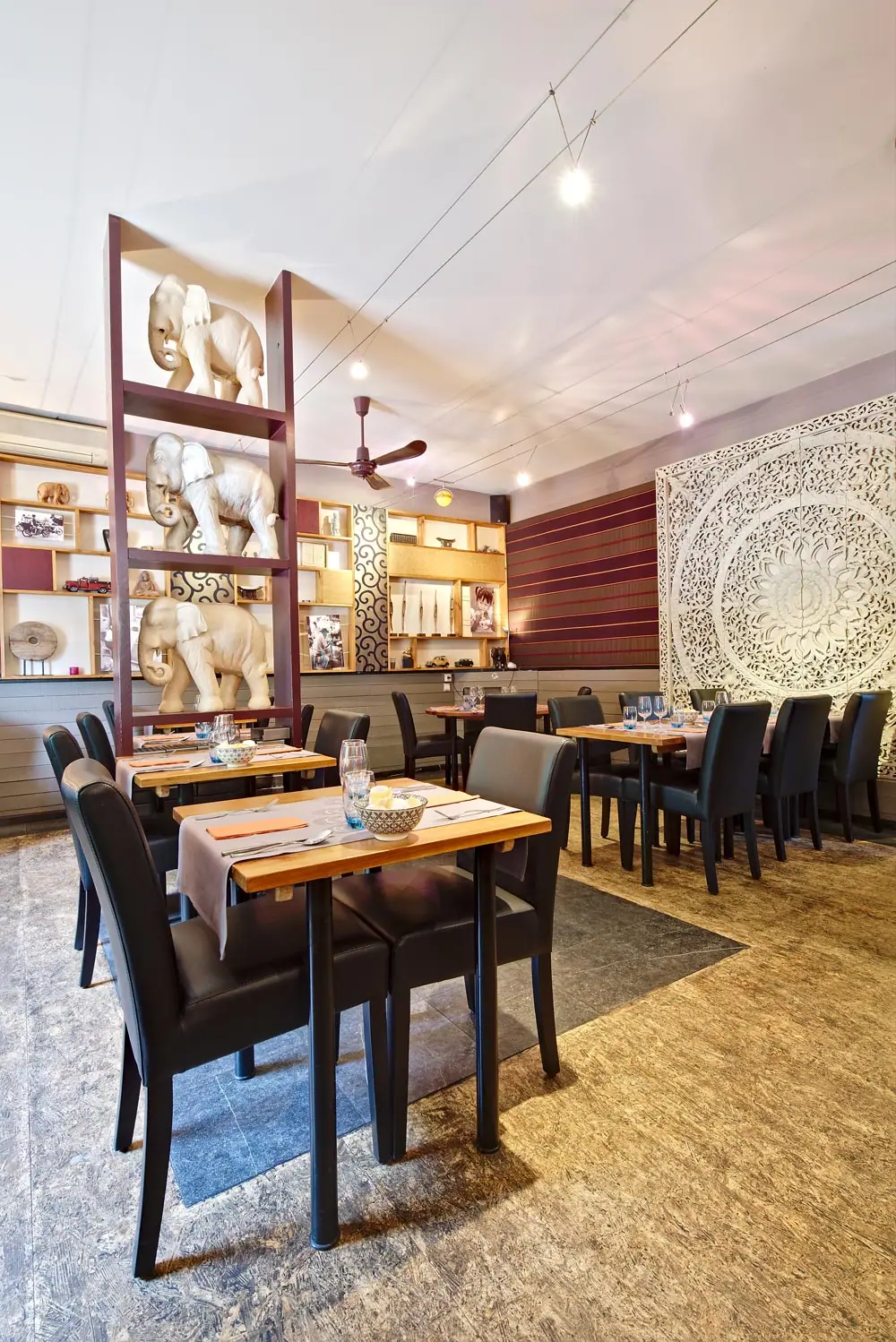 Zaal van het restaurant met een gesculpteerd paneel en olifanten