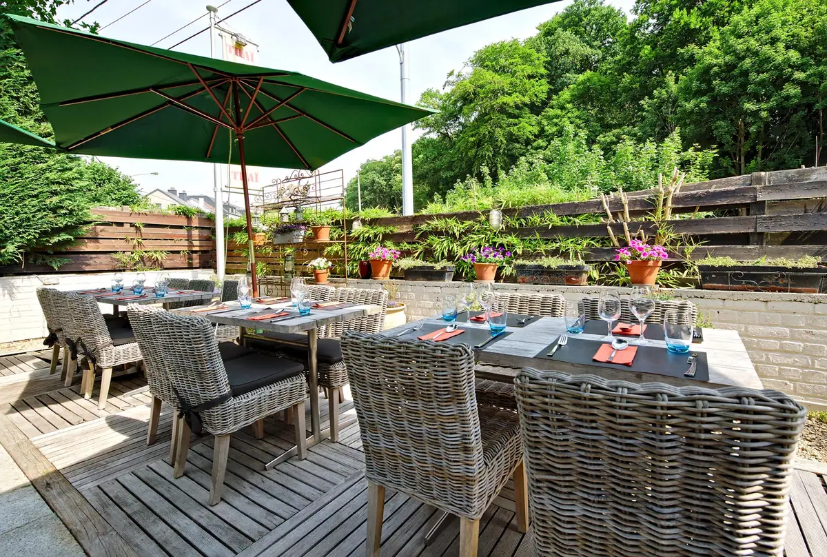Het houten terras met groene parasols tussen het groen